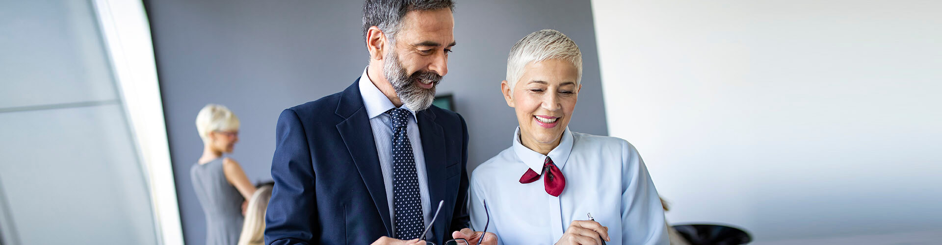 Depósitos Empresas - Hombre y mujer de negocios en una sala de reuniones sonriendo y hablando de negocios