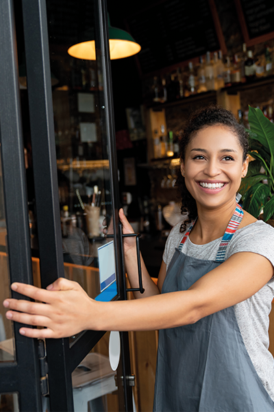 Chica obrint la porta d'un negoci