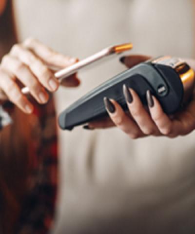 Apple Pay - Persona pagant amb apple pay en el seu mòbil en el tpv d'un comerç