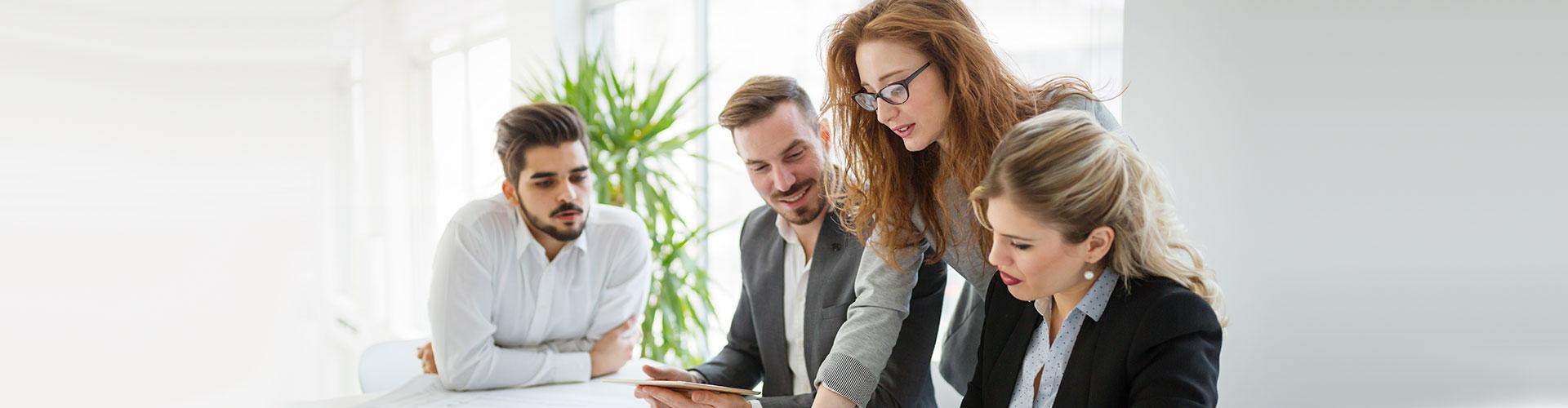 Avales y Garantias - Personas de traje sentados en una mesa en una reunion de equipo revisando papeles en una reunion de negocios