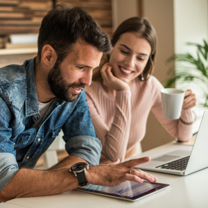 Una pareja joven mirando el ipad sonriendo Una pareja joven mirando el ipad sonriendo