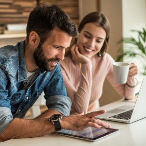 Una pareja joven mirando el ipad sonriendo