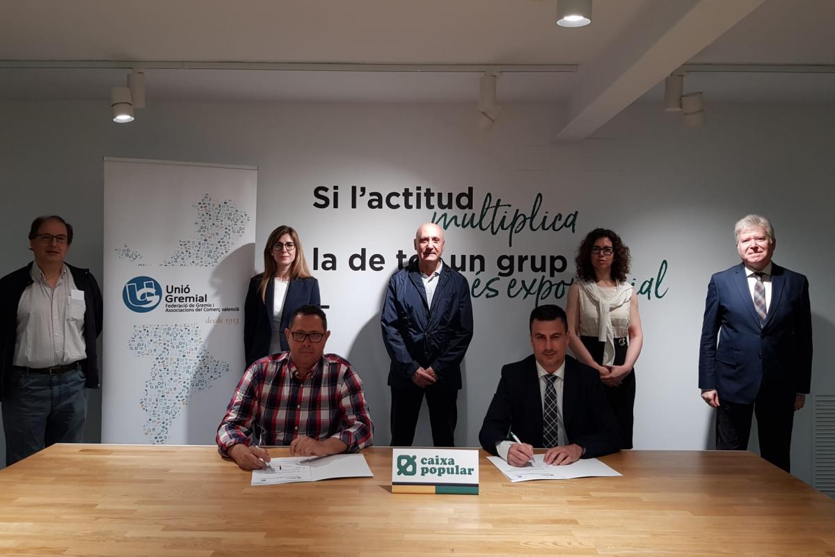 Dos personas sentadas a la mesa firmando el  convenio de colaboración