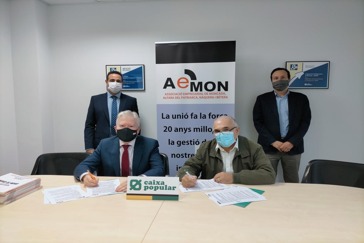 Convenio AEMON - Representantes de Caixa Popular y de AEMON sentados a una mesa firmando un convenio de colaboración