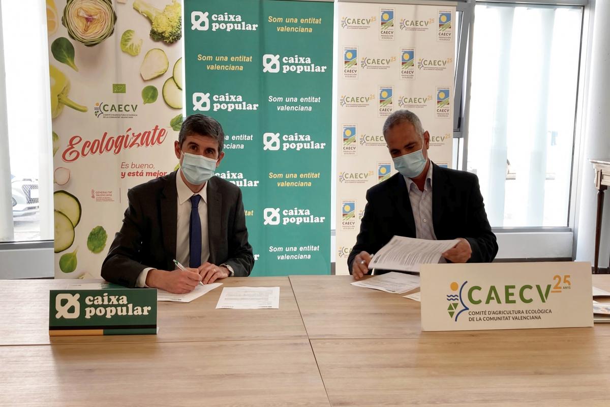 Signatura del conveni entre Caixa Popular i CAECV asseguts a taula
