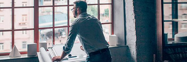 Financiación de exportaciones para empresas - Un hombre de negocios mirando por la ventana